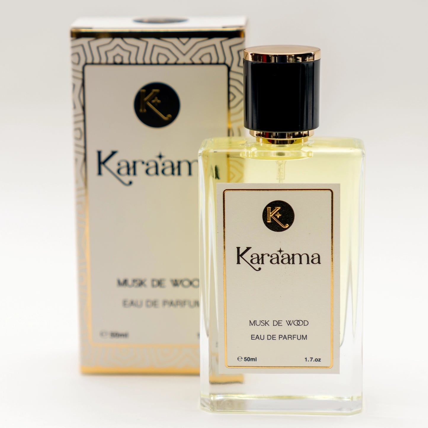 A bottle of Karaama Musk de Wood Eau de Parfum with a gold lid on a white table. The bottle is 50ml or 1.69 fl oz. [karaama.com]