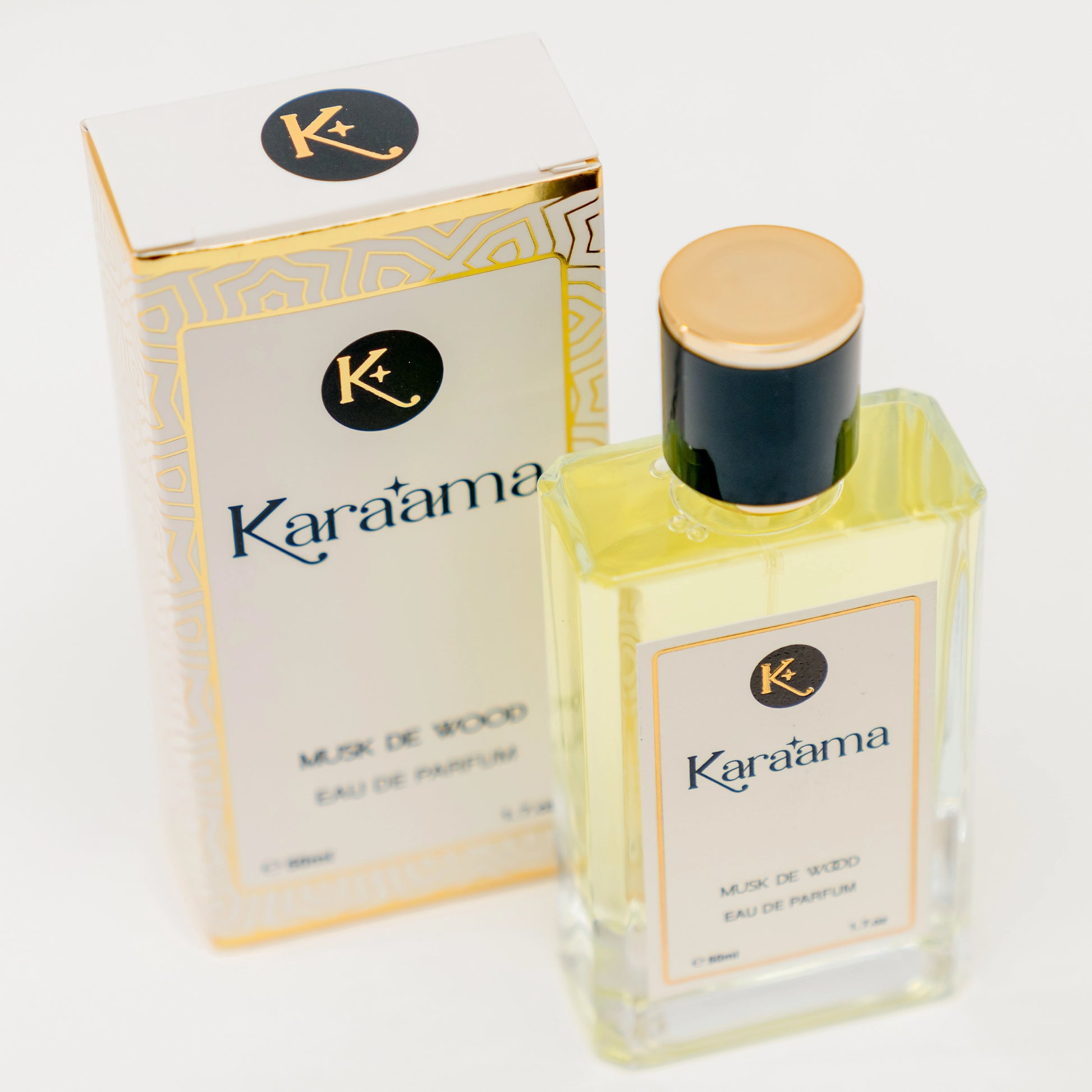 A bottle of Karaama Musk de Wood Eau de Parfum with a gold lid on a white table. The bottle is 50ml or 1.69 fl oz. [karaama.com]