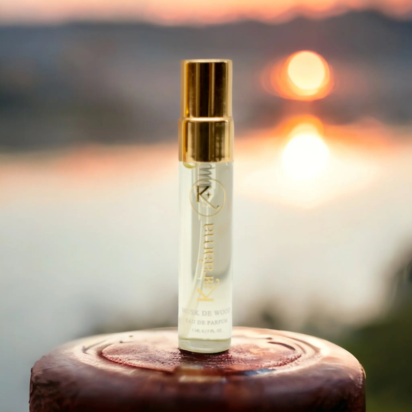 A bottle of Karaama Musk de Wood Eau de Parfum with a gold lid on a wooden fence. The bottle is 5ml or 0.17 fl oz. [karaama.com]